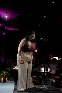 a woman standing on stage with a microphone